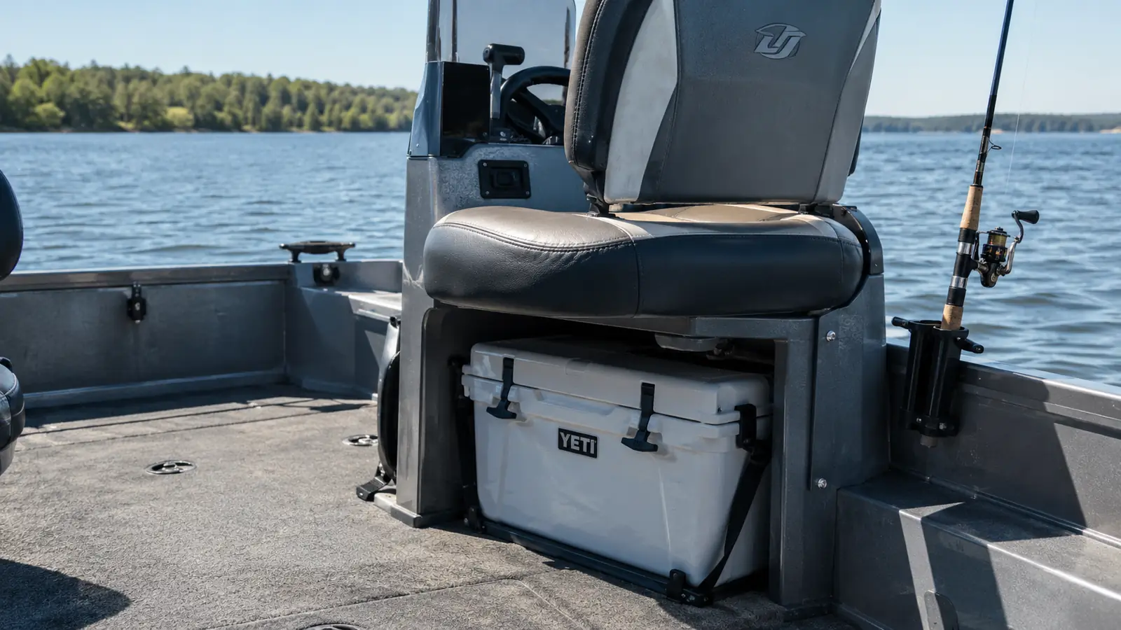 A cooler tucked in the shade under the console of an aluminum fishing boat on a calm lake